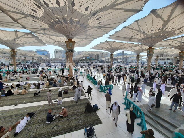 تجمع المسلمون في المجمع الخارجي للمسجد النبوي في المدينة المنورة بالمملكة العربية السعودية، ساحة المسجد النبوي الشريف، الحرم النبوي الشريف، أماكن إسلامية مقدسة، المظلات الالكترونية، معالم دينية إسلامية