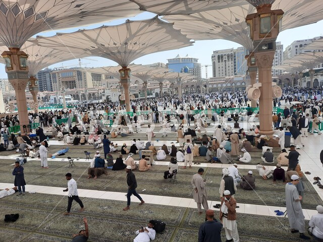 تجمع المسلمون في المجمع الخارجي للمسجد النبوي في المدينة المنورة بالمملكة العربية السعودية، ساحة المسجد النبوي الشريف، الحرم النبوي الشريف، أماكن إسلامية مقدسة، المظلات الالكترونية، معالم دينية إسلامية