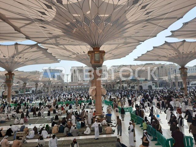 تجمع المسلمون في المجمع الخارجي للمسجد النبوي في المدينة المنورة بالمملكة العربية السعودية، ساحة المسجد النبوي الشريف، الحرم النبوي الشريف، أماكن إسلامية مقدسة، المظلات الالكترونية، معالم دينية إسلامية