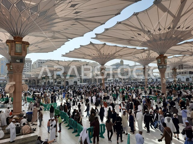 تجمع المسلمون في المجمع الخارجي للمسجد النبوي في المدينة المنورة بالمملكة العربية السعودية، ساحة المسجد النبوي الشريف، الحرم النبوي الشريف، أماكن إسلامية مقدسة، المظلات الالكترونية، معالم دينية إسلامية
