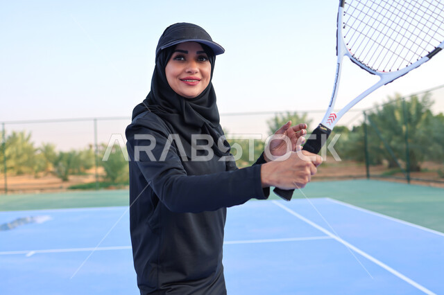 إمرأه عربية خليجية سعودية تلعب كرة المضرب، ممارسة كرة التنس الأرضي في الملاعب العامة، العاب رياضية ، ملعب رياضي، تدريبات رياضية، مضرب رياضي، انشطه نسائيه رياضية، انشطة ورياضات شبابية، نشاط بدني في الهواء الطلق