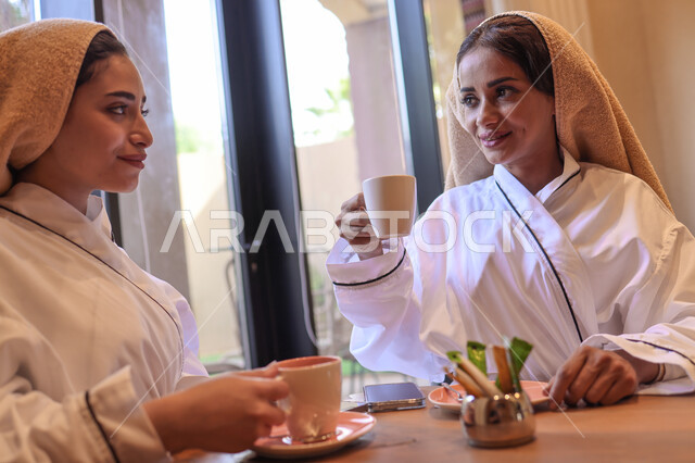 إمرأتان عربيتان خليجيتان سعوديتان في منتجع صحي نسائي، دردشة ومحادثات, تعارف وصداقات, الإستمتاع بشرب المشروبات, غرفة الإسترخاء و الراحة والاستجمام، نادي صحي نسائي، الاهتمام والعناية بالمظهر، صالون وسبا نسائي, وقت ممتع مع الأصدقاء