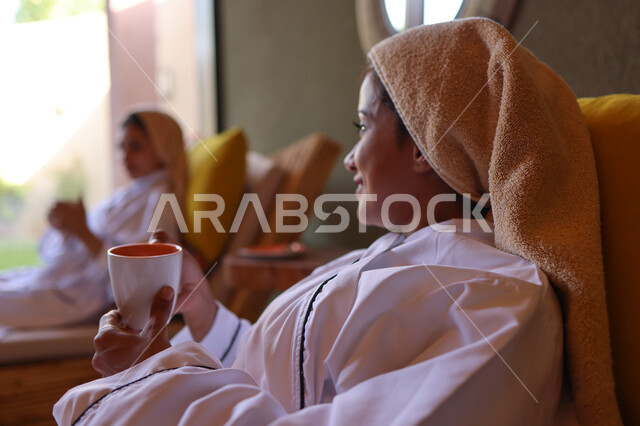 إمرأتان عربيتان خليجيتان سعوديتان في منتجع صحي نسائي، دردشة ومحادثات, تعارف وصداقات, الإستمتاع بشرب المشروبات, غرفة الإسترخاء و الراحة والاستجمام، نادي صحي نسائي، الاهتمام والعناية بالمظهر، صالون وسبا نسائي, وقت ممتع مع الأصدقاء