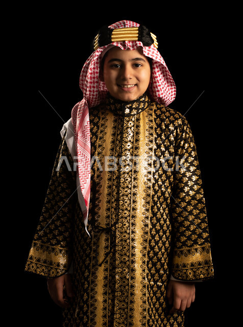 بورتريه لولد عربي خليجي سعودي يرتدي زي تراثي سعودي للمناسبات الوطنية والاحتفالية، تاسيس المملكة العربية السعودية، ذكرى اليوم الوطني السعودي، زي سعودي شعبي، يوم التأسيس السعودي، العيد الوطني السعودي، أزياء يوم التأسيس، خلفية سوداء