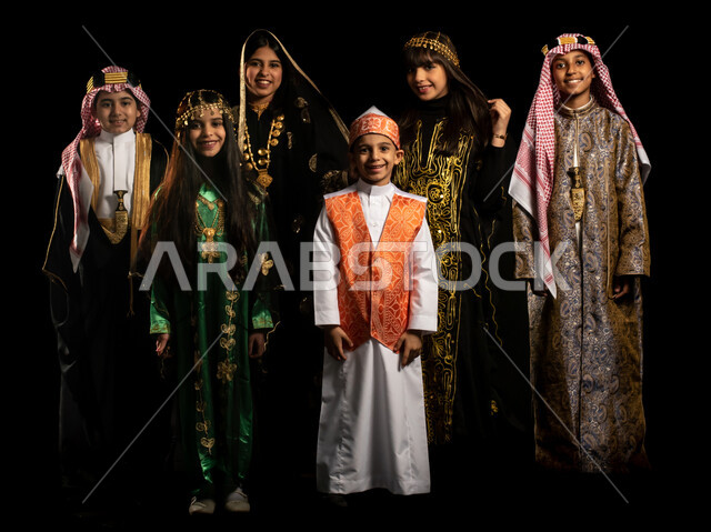 بورتريه لمجموعة من الاطفال العرب الخليجيين السعوديين يرتدون زي تراثي للمناسبات الوطنية والاحتفالية، تاسيس المملكة العربية السعودية، ذكرى اليوم الوطني السعودي، يوم التأسيس السعودي، العيد الوطني السعودي، ازياء شعبية، صورة الجسم بالطول الكامل، خلفية سوداء