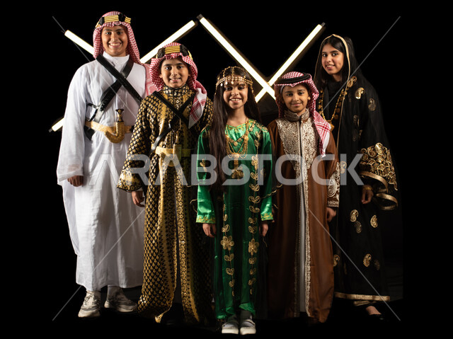 بورتريه لمجموعة من الاطفال العرب الخليجيين السعوديين يرتدون زي تراثي للمناسبات الوطنية والاحتفالية، تاسيس المملكة العربية السعودية، ذكرى اليوم الوطني السعودي، يوم التأسيس السعودي، العيد الوطني السعودي، ازياء شعبية، صورة الجسم بالطول الكامل، خلفية سوداء