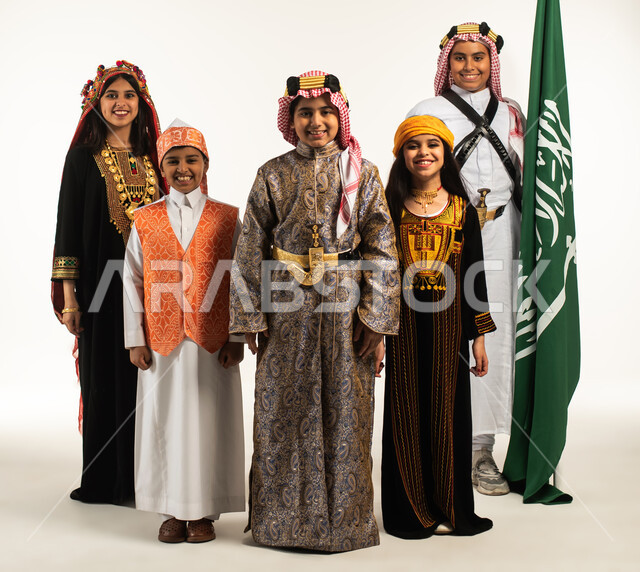 بورتريه مجموعة من الأطفال العرب السعوديون، بجانب علم السعودية، أزياء شعبية سعودية في المنطقة الوسطى والجنوبية والغربية والشمالية، الإحتفالات الوطنية، هوية اليوم الوطني السعودي 92، يوم التأسيس السعودي، زي تراثي سعودي للمناسبات الوطنية، صورة بالطول الكامل