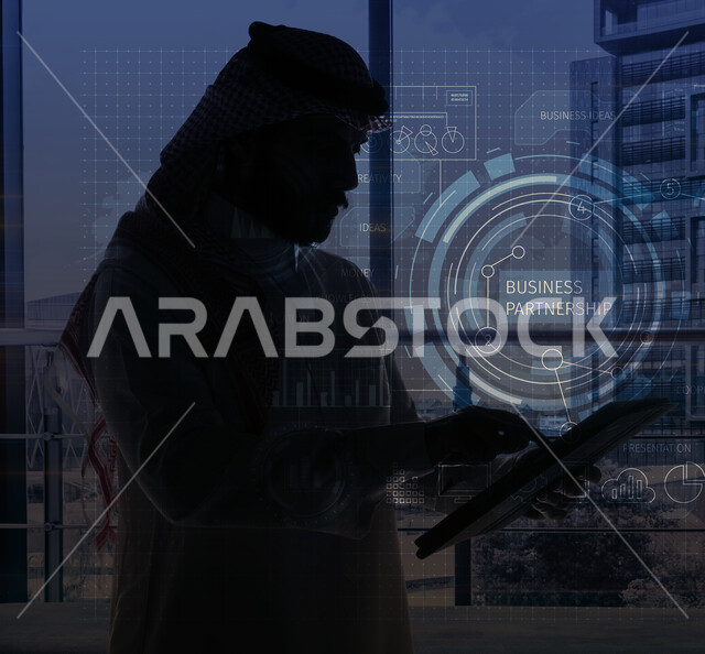 صورة مقربة لرجل اعمال عربي خليجي سعودي يستخدم التابليت المحمول، العمل في مقر الشركة، انجاز المهام من خلال جهاز لوحي، استخدام تقنية الهولوجرام ثلاثية الابعاد، رسومات بيانية، العمل عن بعد، متابعة وادارة العمل، بيئة العمل السعودية