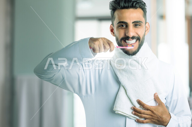 صورة مقربة لرجل عربي خليجي سعودي يقوم بتنظيف أسنانه، فرشاة الأسنان، العناية والإهتمام بصحة ونظافة الأسنان، نظافة الفم، تجنب تسوس الاسنان وامراض اللثة
