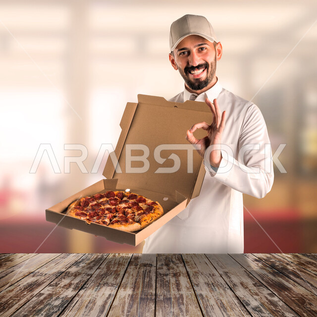 بورتريه لرجل عربي خليجي سعودي يحمل بيده فطيرة البيتزا، خدمات توصيل الطعام، توصيل الطلبات، التوصيل السريع، طلبات الدليفري، خدمات التوصيل المنزلي، الخدمات اللوجستية