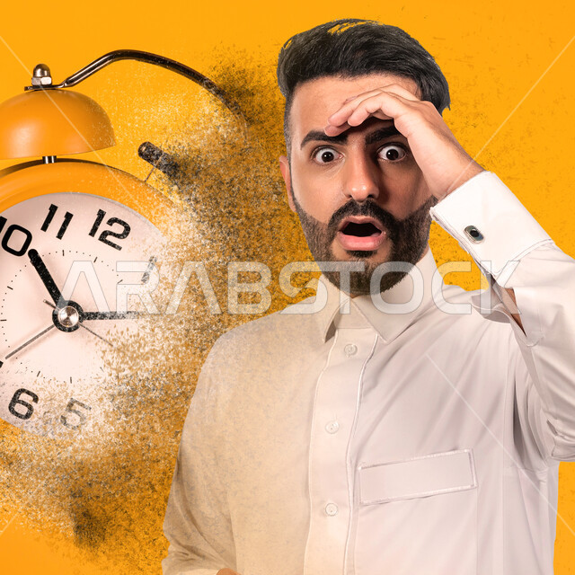 بورتريه لرجل عربي خليجي سعودي مذهول، ايماءات وجه ويدين تدل على الدهشة والذهول، الاستغراب والتعجب، ساعة تنبه رقمية، منبه، خلفية صفراء