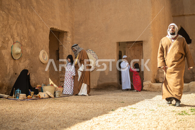 مجموعة من الأشخاص داخل سوق شعبي قديم، أعمال وصناعات يدوية، حرفة يدوية تاريخية، احياء التراث الشعبي الخليجي، مهن وحرف يدوية شعبية، يوم التأسيس السعودي، تأسيس المملكة 1727م ، أزياء شعبية سعودية، السعودية القديمة، بيوت طينية تراثية قديمة