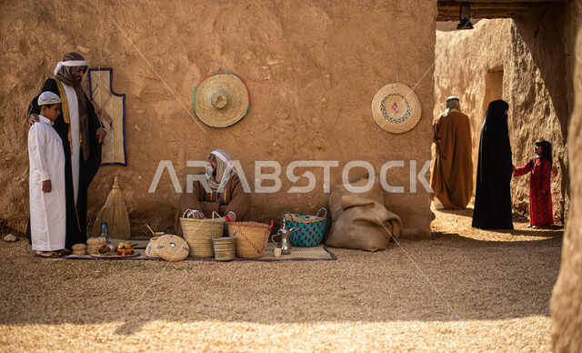 مجموعة من الأشخاص داخل سوق شعبي قديم، أعمال وصناعات يدوية، احياء التراث الشعبي الخليجي، مهن وحرف يدوية شعبية، يوم التأسيس السعودي، تأسيس المملكة 1727م ، أزياء شعبية سعودية، السعودية القديمة، بيوت طينية تراثية قديمة