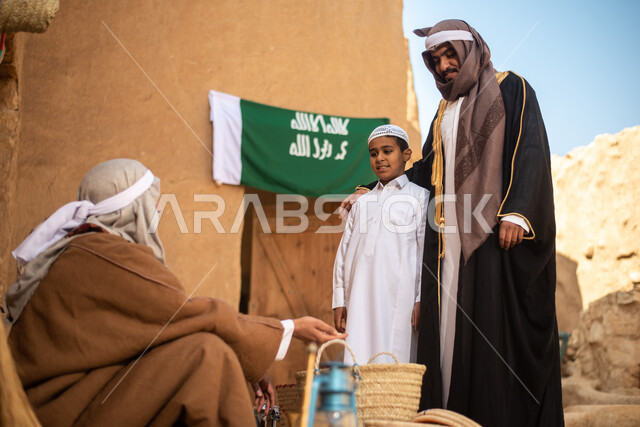 A group of people inside an old popular market, handicrafts and works, revival of Gulf folklore, popular handicrafts and professions, Saudi founding day, the founding of the Kingdom 1727 AD, Saudi folk costumes, old Saudi Arabia, old traditional mud house