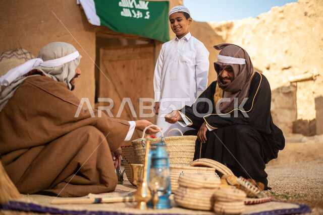 مجموعة من الأشخاص داخل سوق شعبي قديم، أعمال وصناعات يدوية، احياء التراث الشعبي الخليجي، مهن وحرف يدوية شعبية، يوم التأسيس السعودي، تأسيس المملكة 1727م ، أزياء شعبية سعودية، السعودية القديمة، بيوت طينية تراثية قديمة