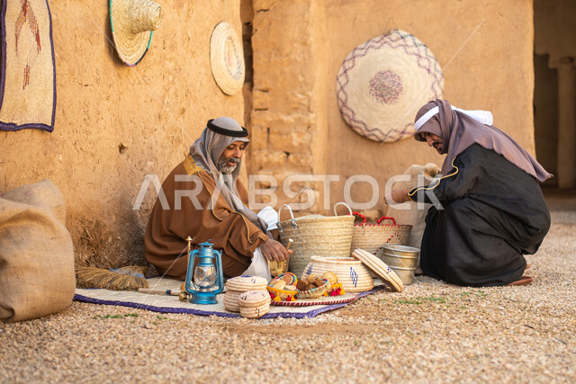 مجموعة من الأشخاص داخل سوق شعبي قديم، أعمال وصناعات يدوية، احياء التراث الشعبي الخليجي، مهن وحرف يدوية شعبية، يوم التأسيس السعودي، تأسيس المملكة 1727م ، أزياء شعبية سعودية، السعودية القديمة، بيوت طينية تراثية قديمة