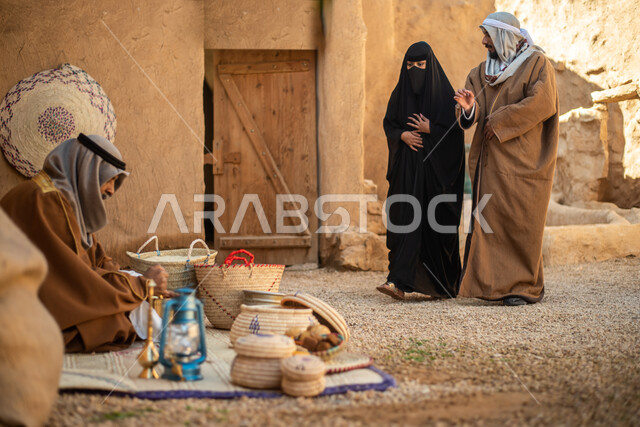 مجموعة من الأشخاص داخل سوق شعبي قديم، أعمال وصناعات يدوية، احياء التراث الشعبي الخليجي، مهن وحرف يدوية شعبية، يوم التأسيس السعودي، تأسيس المملكة 1727م ، أزياء شعبية سعودية، السعودية القديمة، بيوت طينية تراثية قديمة