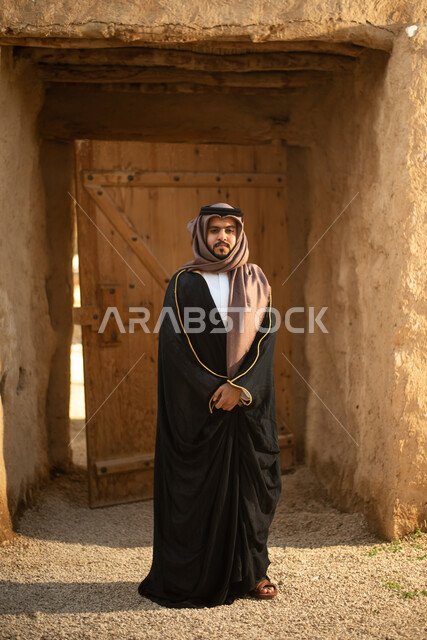 رجل عربي خليجي سعودي، يوم التأسيس السعودي، تأسيس المملكة 1727م ، أزياء شعبية سعودية، السعودية القديمة، بيوت طينية تراثية قديمة، زي تراثي سعودي للمناسبات الوطنية، صورة بالطول الكامل