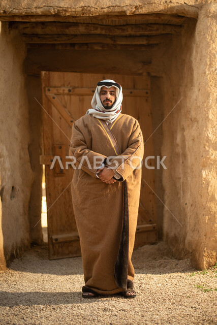 رجل عربي خليجي سعودي، يوم التأسيس السعودي، تأسيس المملكة 1727م ، أزياء شعبية سعودية، السعودية القديمة، بيوت طينية تراثية قديمة، زي تراثي سعودي للمناسبات الوطنية، صورة بالطول الكامل