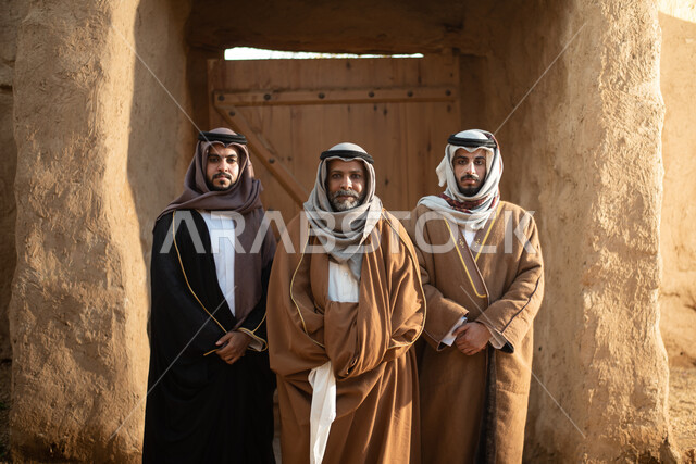 مجموعة من الرجال العرب السعوديون، يوم التأسيس السعودي، تأسيس المملكة 1727م ، أزياء شعبية سعودية، السعودية القديمة، بيوت طينية تراثية قديمة، زي تراثي سعودي للمناسبات الوطنية