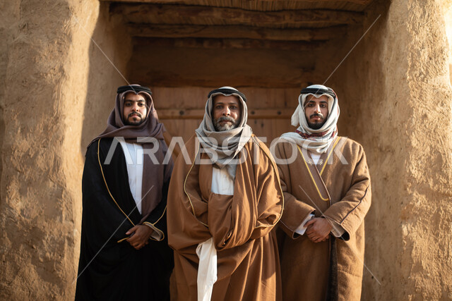 مجموعة من الرجال العرب السعوديون، يوم التأسيس السعودي، تأسيس المملكة 1727م ، أزياء شعبية سعودية، السعودية القديمة، بيوت طينية تراثية قديمة، زي تراثي سعودي للمناسبات الوطنية