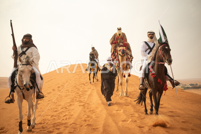 فارسان عربيان خلجيان سعوديان يمتطيان الخيول في الصحراء السعودية، استخدام البندقية السعودية، رفع العلم السعودي، ارتداء ازياء شعبية تراثية، رجل ملثم يركب الجمل، احياء ذكرى التاسيس السعودي، الدولة السعودية الاولى 1727م، يوم التاسيس السعودي، عيد وطني سعودي
