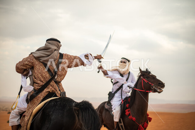 فارسان عربيان خليجيان سعوديان يمتطيان الخيل في الصحراء السعودية ويتبارزان، مبارزة السيوف، ارتداء زي تراثي شعبي، احياء ذكرى التاسيس السعودي، الدولة السعودية الاولى 1727م، يوم التاسيس السعودي، عيد وطني سعودي