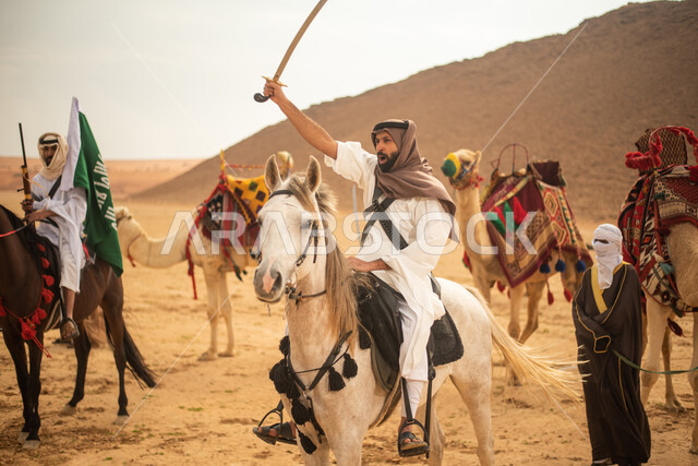 فرسان عرب خلجيين سعوديين يمتطون الخيول في الصحراء السعودية، استخدام السيوف والبنادق، رفع العلم السعودي، ارتداء ازياء شعبية تراثية، احياء ذكرى التاسيس السعودي، الدولة السعودية الاولى 1727م، يوم التاسيس السعودي، عيد وطني سعودي