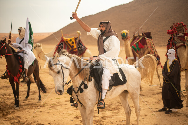 فرسان عرب خلجيين سعوديين يمتطون الخيول في الصحراء السعودية، استخدام السيوف والبنادق، رفع العلم السعودي، ارتداء ازياء شعبية تراثية، احياء ذكرى التاسيس السعودي، الدولة السعودية الاولى 1727م، يوم التاسيس السعودي، عيد وطني سعودي