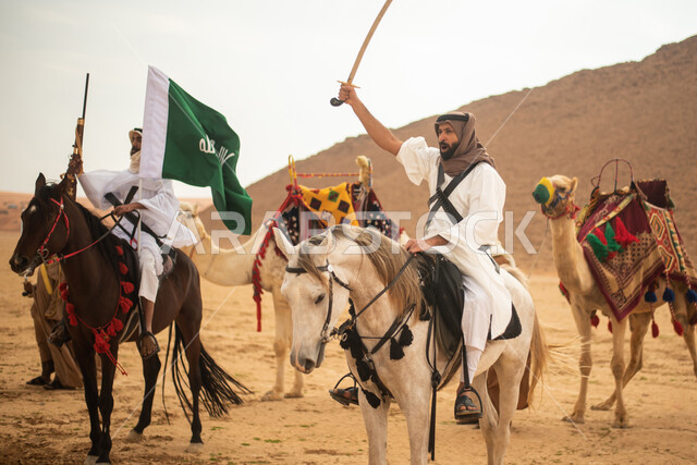 فرسان عرب خلجيين سعوديين يمتطون الخيول في الصحراء السعودية، استخدام السيوف والبنادق، رفع العلم السعودي، ارتداء ازياء شعبية تراثية، احياء ذكرى التاسيس السعودي، الدولة السعودية الاولى 1727م، يوم التاسيس السعودي، عيد وطني سعودي