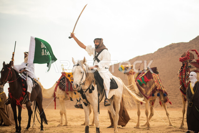 فرسان عرب خلجيين سعوديين يمتطون الخيول في الصحراء السعودية، استخدام السيوف والبنادق، رفع العلم السعودي، ارتداء ازياء شعبية تراثية، احياء ذكرى التاسيس السعودي، الدولة السعودية الاولى 1727م، يوم التاسيس السعودي، عيد وطني سعودي