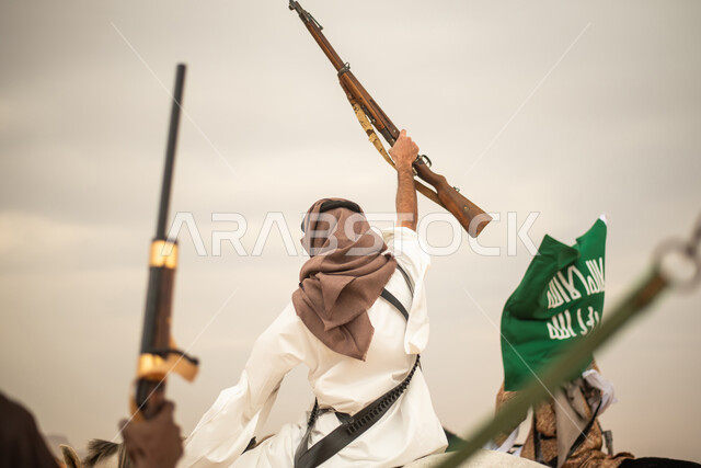 فرسان عرب خلجيين سعوديين يمتطون الخيول في الصحراء السعودية، استخدام البندقية السعودية، رفع العلم السعودي، ارتداء ازياء شعبية تراثية، احياء ذكرى التاسيس السعودي، الدولة السعودية الاولى 1727م، يوم التاسيس السعودي، عيد وطني سعودي