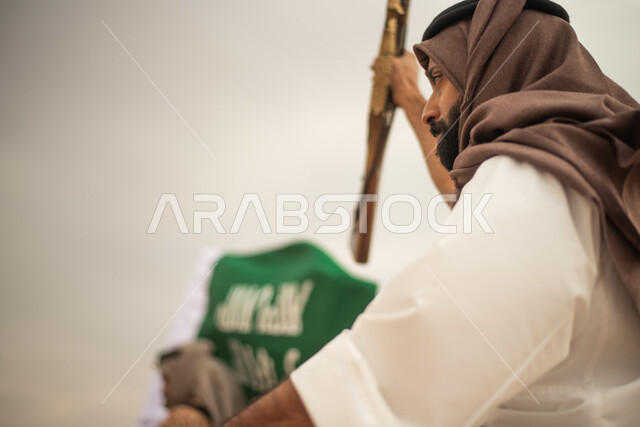 Saudi Gulf Arab knights riding horses in the Saudi desert, using the Saudi rifle, raising the Saudi flag, wearing traditional folk costumes, commemorating the Saudi founding, the first Saudi state 1727 AD, Saudi founding day, Saudi national holiday