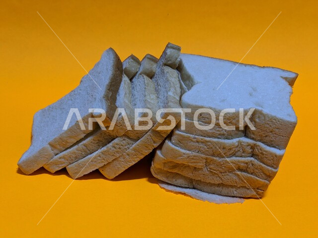 Slices of white toast on a yellow background, baked