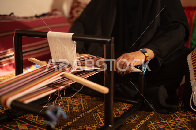 A close-up of the hand of a Saudi Arab Gulf woman who weaves and spins ...