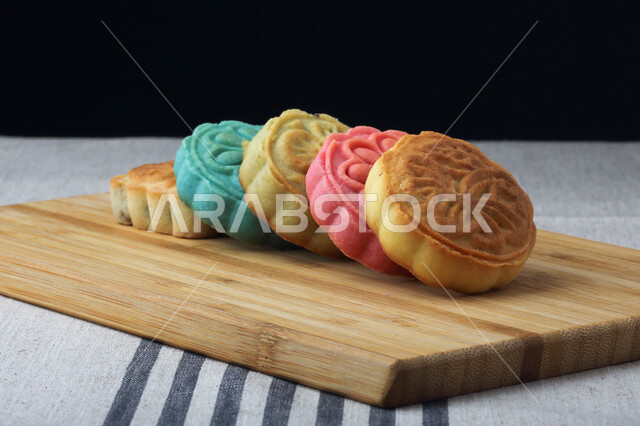 Square colored date maamoul, fragile popular sweets on a wooden board, Eid cakes