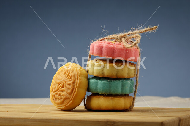 معمول التمر ملون مربع الشكل ، الحلويات الشعبية الهشة على لوح خشبي ، كعك العيد 