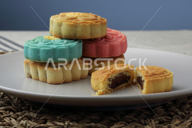 معمول التمر ملون مربع الشكل ، الحلويات الشعبية الهشة على لوح خشبي ، كعك العيد 