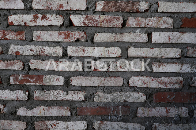 A wall made of gray bricks, a corrugated wall, a brick mold, wallpaper, an old wall background with a prominent shape.