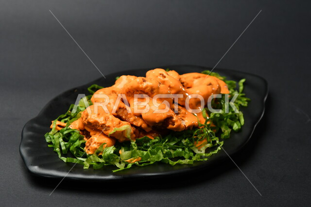 طبق روبيان مع الصوص على سطح أسود ، مطابخ ومطاعم عربية ، الجمبري ، مأكولات بحرية