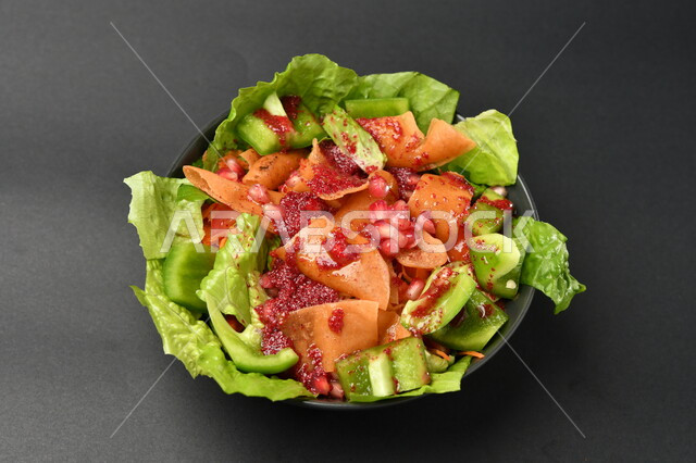 طبق سلطة خضراوات مع الخبز المقلي على سطح أسود ، طبق صحي ، مقبلات باردة ، حمية غذائية صحية