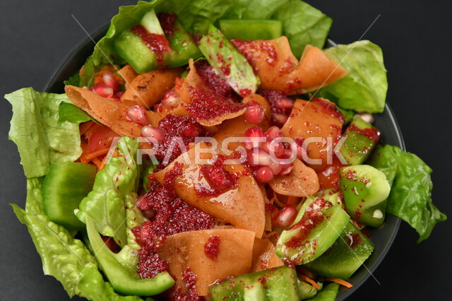 طبق سلطة خضراوات مع الخبز المقلي على سطح أسود ، طبق صحي ، مقبلات باردة ، حمية غذائية صحية