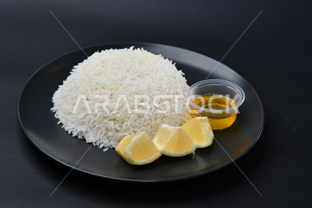 طبق أرز أبيض مع شرائح الليمون على سطح أسود ، مأكولات عربية ، مطعم سعودي ، أطباق خليجية ، مطبخ سعودي