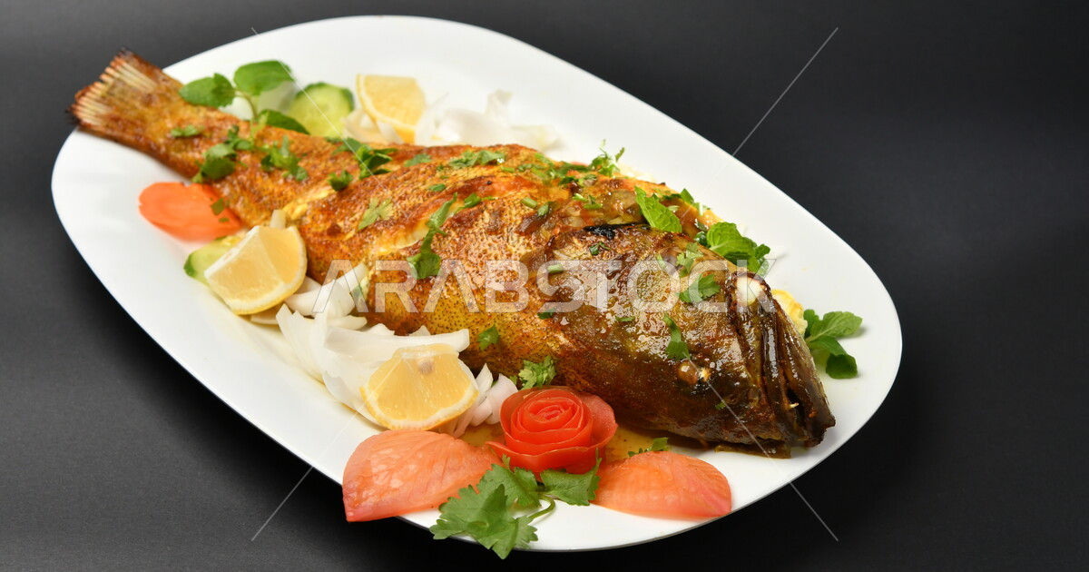 A plate of marinated fried fish on a blackened surface, seafood, arabic