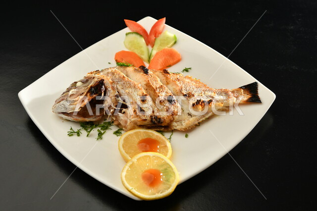 طبق من السمك  المتبل الشهي ، مأكولات بحرية ، مأكولات عربية ، وجبة طعام غذائية صحية 