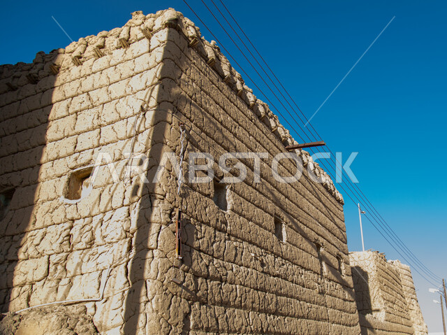 A wall of an old house made of mud in the Asir region in Ahad Rufaidah, archaeological historical places in the Kingdom of Saudi Arabia, old buildings, old historical houses.