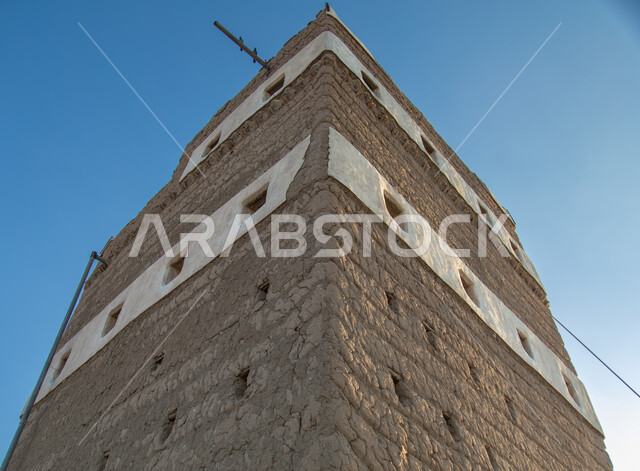Windows of a restored heritage house made of clay and stacked stones in the Asir region in Ahad Rufaidah, historical archaeological sites in the Kingdom of Saudi Arabia, old buildings, old historical houses.