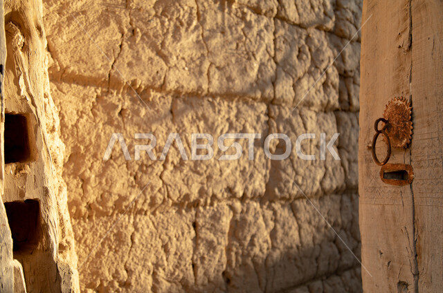 An old open heritage door, historical doors, an old wall, an antique wooden door, archaeological historical places in the Kingdom of Saudi Arabia, old historical houses.