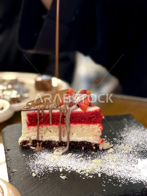 قطعة من حلى تشيز كيك وقطع الفراولة والشوكولاته السائحة والسكر المرشوش،  حلويات وسكريات, حلا قهوه, أطعمه ذات سعرات حراريه عاليه