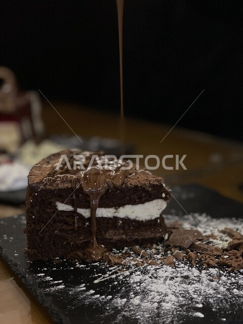 قطعة من حلى كيك الشوكولاه مع الشوكولاه الذائبة والسكر المرشوش،  حلويات وسكريات, حلا قهوه, حلويات ذات سعرات حراريه عاليه